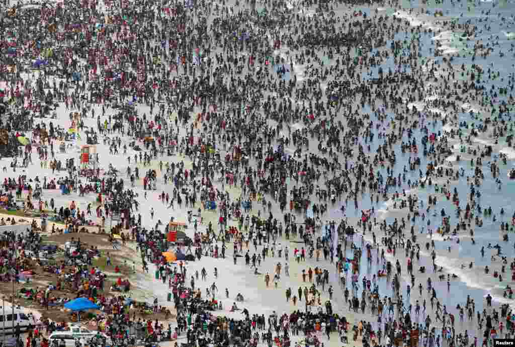 Crowds of revelers enjoy New Year&#39;s Day on a beach at Muizenberg in Cape Town, South Africa.