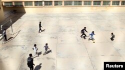 FILE - Libyan displaced boys, who fled their house because of the fighting between the Eastern forces commanded by Khalifa Haftar and the internationally recognised government, play soccer at Bader School, which is used as a shelter, in Tripoli, Libya, Ap