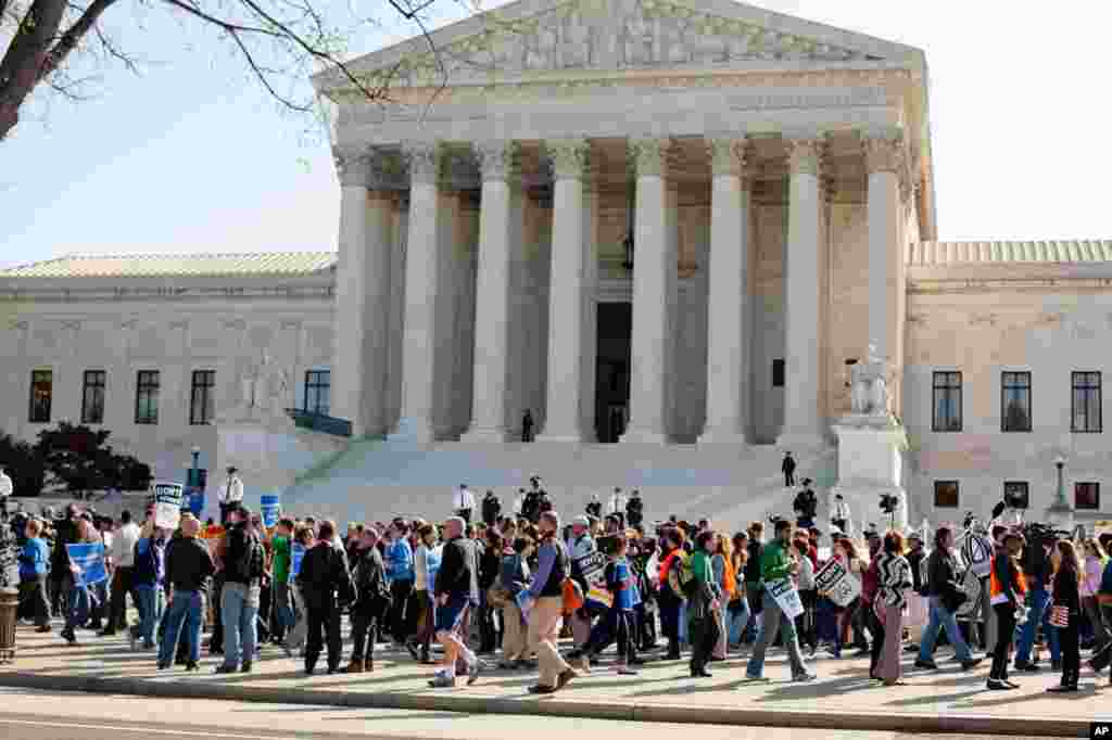 People rallying on the sidewalk as legal arguments over the health care law took place at the Supreme Court, March 26, 2012. (Alison Klein/VOA)
