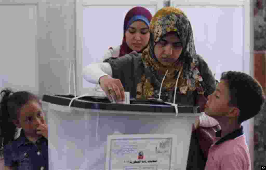 An Egyptian boy looks at his mother as she casts her vote during the second day of the presidential election in a polling station in Alexandria, Egypt, Thursday, May 24, 2012. In a wide-open race that will define the nation's future political course, Egy