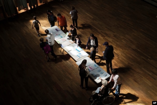 Voters pick up ballots before voting in Lyon, France, May 26, 2019.