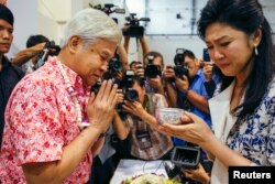 FILE - Former Thai Prime Minister Yingluck Shinawatra weeps as she takes part in Songkran festival celebration with opposition Puea Thai party members at the party headquarters in Bangkok, Thailand, April 7, 2016.