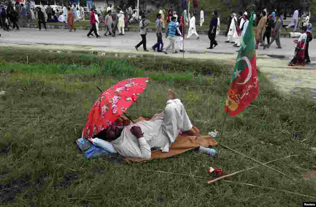 تحریک انصاف کا ایک کارکن تھک کر آرام کر رہا ہے۔