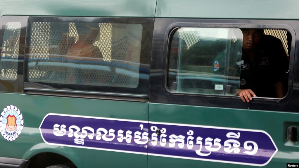រូបឯកសារ៖ លោក អ៊ួន ឈិន និងលោក យាង សុធារិន អតីតអ្នករាយការណ៍របស់វិទ្យុអាស៊ីសេរី អង្គុយនៅក្នុងរថយន្តដឹកអ្នកទោស នៅពេលដែលពួកគេបានមកដល់តុលាការឧទ្ធរណ៍ នៅរាជធានីភ្នំពេញ កាលពីថ្ងៃទី១៩ ខែមេសា ឆ្នាំ២០១៨។ (រូបថត Reuters)