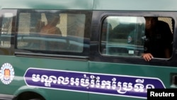 Uon Chhin and Yeang Sothearin, former journalists of the Radio Free Asia (RFA), sit inside a police vehicle as they arrive for a bail hearing at the Appeal Court in Phnom Penh, Cambodia, April 19, 2018.