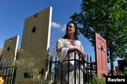 FILE - British landscape designer Juliet Sargeant stands in her "Modern Slavery Garden" on display at the Chelsea Flower Show in London, May 23, 2016.