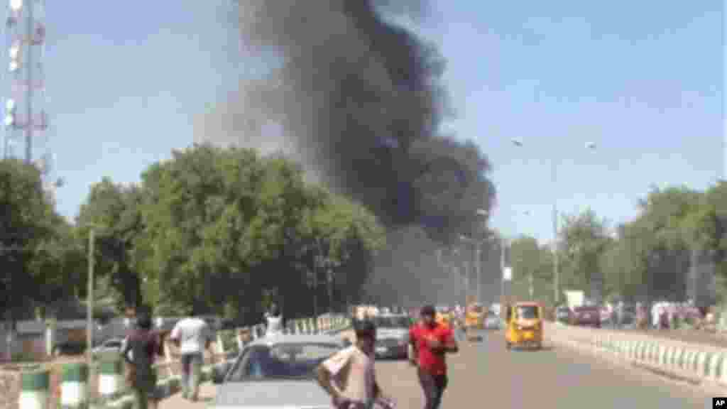 Mutane suna gudu yayin da hayaki ke shiga cikin samaniya bayan da bom ya fashe a inda sojoji ke girke a garin Maiduguri, Junairu 14, 2014.