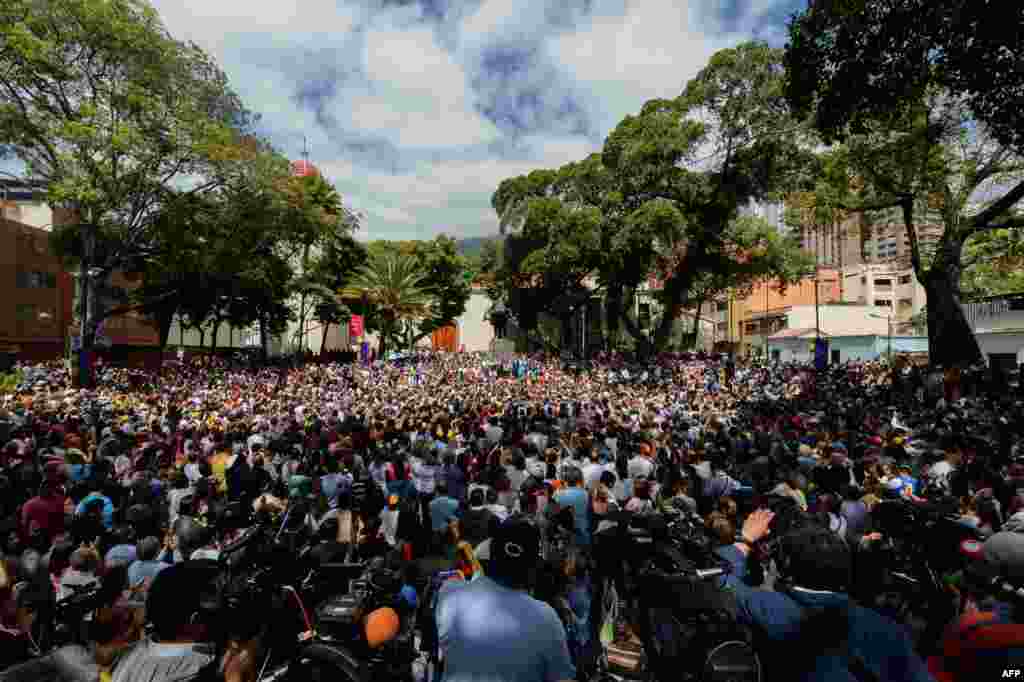 Opposition supporters gather to listen to Venezuela&#39;s National Assembly head and the country&#39;s self-declared &#39;acting president&#39; Juan Guaido, at Bolivar Square in Chacao, eastern Caracas.