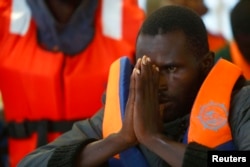 An African rescued by the Migrant Offshore Aid Station reacts as the ship Phoenix reaches Sicily's port of Pozzallo. The charity provided this courtesy photo Oct. 5, 2014.