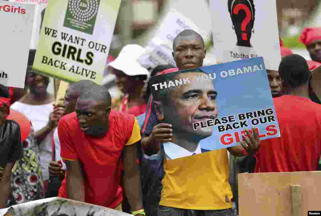 Para pengunjuk rasa di Lagos, membawa papan bertuliskan pesan untuk pembebasan siswi yang diculik dari desa Chibok (9/5).