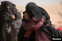 Women hug near the village of Baghuz, Deir el-Zour province, in Syria, March 7, 2019.