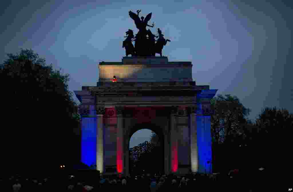 A member of the British military plays a bugle on top of Wellington Arch before the start of a two minutes silence during a dawn service to mark the 99th Anzac Day on Hyde Park Corner in London.