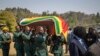 Le cercueil de l'ancien président Robert Mugabe est transporté dans un hélicoptère de l'armée de l'air depuis sa résidence officielle à Harare, dans la capitale du Zimbabwe, le jeudi 12 septembre 2019. (AP Photo / Ben Curtis)