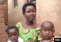 Hyacinthe Murayire, married to Stanislas Niyomungeri, holds two of their three children. Her father-in-law confessed to killing her father's brother and that man's family.