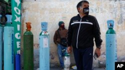 Des mexicains dans l'attente de remplir leurs bonbonnes d'oxygène pour lutter contre la COVID-19 à Mexico, 27 décembre 2020 (AP Photo/Ginnette Riquelme)