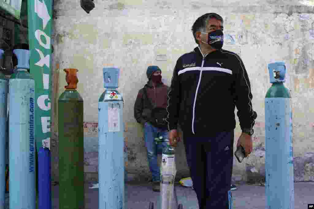 Jorge Perez lines up to refill an oxygen tank for a family member sick with COVID-19 in Mexico City, December 27, 2020.