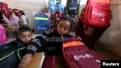 Syrian children unpack their backpacks — donated by UNICEF — inside a classroom in Ras al-Ain city, Syria, Feb. 1, 2016.