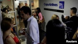 People gather at the gates of Copa Airlines headquarters in Caracas, Venezuela, April 6, 2018. Venezuela cut commercial ties with Panama, including Copa Airlines, over accusations of money laundering.