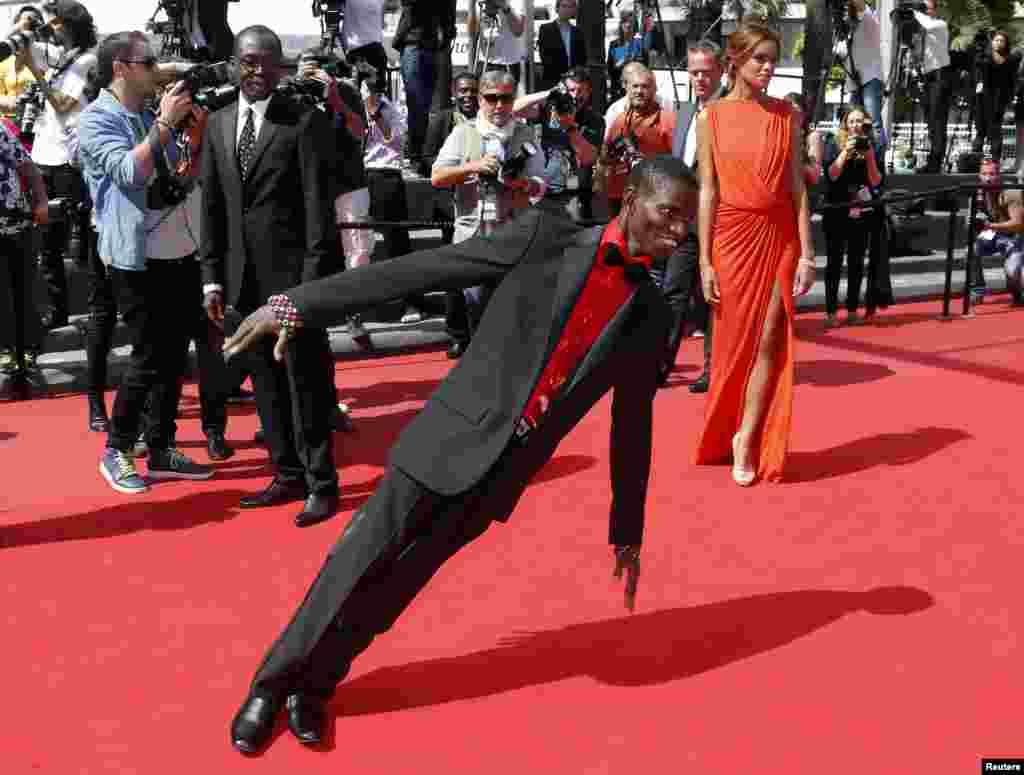 Cast member Souleymane Deme (C) performs on the red carpet as he arrives with director Mahamat-Saleh Haroun (L) and cast member Anais Monory for the screening of the film &quot;Grigris&quot; during the 66th Cannes Film Festival in Cannes, France.