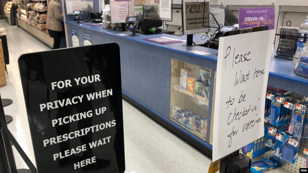 华盛顿近郊一家杂货店兼药店内提示包括无预约者在内的顾客排队等候接种新冠疫苗的标牌。(2021年12月2日)(photo:VOA)
