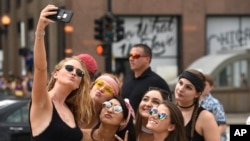 A group of festival goers gathered to take selfies at the entrance of Lollapalooza, Thursday, Aug. 3, 2017, in Chicago. Lollapalooza draws in crowds of music enthusiasts yearly. (AP Photo/G-Jun Yam)