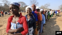 FILE: Women queue for food assistance distributed by the United Nations World Food Programme in Mwenezi, about 450 kilometers (280 miles) south of Harare, Zimbabwe, Wednesday, Sept. 9 2015.