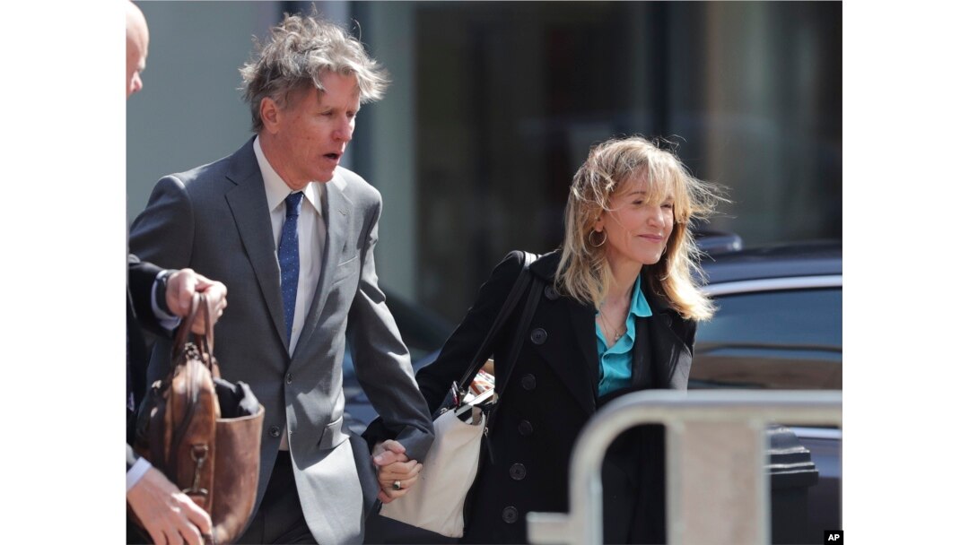 FILE - Actress Felicity Huffman arrives holding hands with her brother Moore Huffman Jr., left, at federal court in Boston, Massachusetts, April 3, 2019, to face charges in a nationwide college admissions bribery scandal.