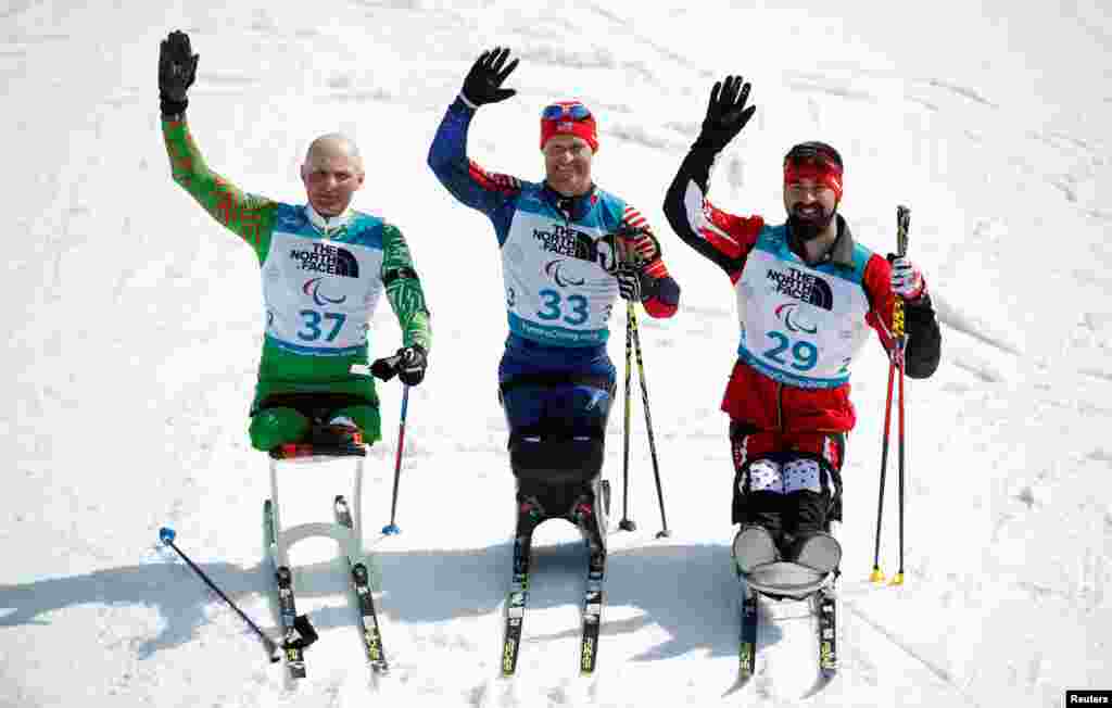 Gold medalist Daniel Cnossen (33) of the U.S., silver medalist Dzmitry Loban (37) of Belarus and bronze medalist Collin Cameron (29) of Canada in the Men's 7.5km Sitting Biathlon at 2018 Winter Paralympics in Pyeongchang, South Korea, March 10, 2018.