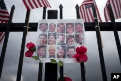 FILE - In this Nov. 18, 2016 photo, a faded collage shows images of the 14 victims who were killed in the Dec. 2, 2015, San Bernardino, California, terror attack.