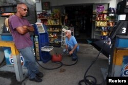 Men buy gasoline in Maunabo, Jan. 27, 2018.