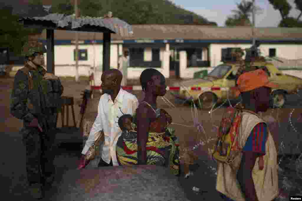 People pass through a security checkpoint manned by French peacekeeping soldiers and local gendamerie at Kilometre 12 in Bangui, March 3, 2014. 