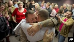 FILE - Chris Serrano, left, and Clifton Webb embrace after being married, as people wait in line to get licenses outside of the marriage division of the Salt Lake County Clerk's Office in Salt Lake City, Utah, Dec. 20, 2013.