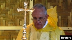 Pope Francis, in a rain poncho,during a Mass near Tacloban airport, The Philippines, Jan. 17, 2015.