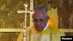 FILE - Pope Francis, shown in a rain poncho during a Mass near the Tacloban airport, said during his trip this month to the typhoon-vulnerable Philippines that "man has gone too far damaging the environment."