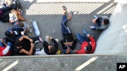 Refugees rest in the shadow after arriving in Freilassing at the border between Austria and Germany, southern Germany, Sept. 16, 2015.