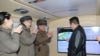 North Korean leader Kim Jong Un speaks with officials during an observation of what state media report is a hypersonic missile test at an undisclosed location in North Korea, January 11, 2022, in this photo released January 12, 2022 by North Korea's Korean Central News Agency.