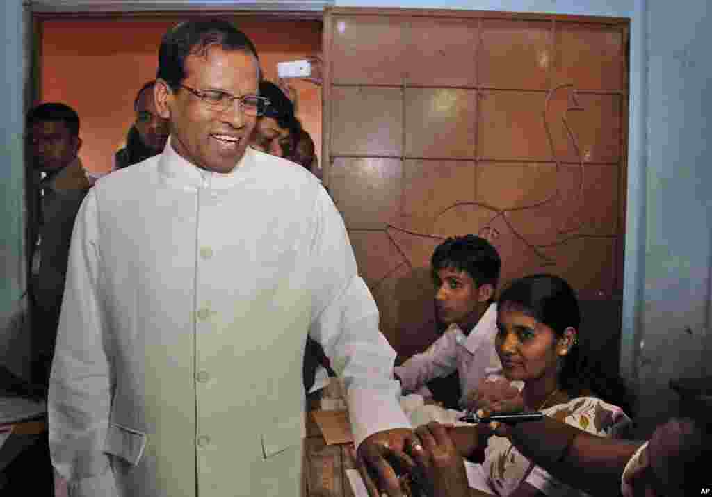 Sri Lanka&#39;s main opposition presidential candidate Mithripala Sirisena gets his finger marked with indelible ink after casting his vote at a polling station in Polonnaruwa, about 200 kilometers northeast of Colombo, Sri Lanka, Jan. 15, 2015.&nbsp;