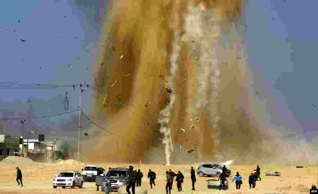 Palestinians run for cover as smoke rises following an Israeli airstrike on a Hamas post, in the northern Gaza Strip. Israel struck a number of Hamas positions in Gaza after a &quot;projectile&quot; fired from the Palestinian enclave crashed in a border area, the Israeli army said.