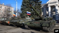 Military vehicles, one flying a Russian flag, are seen parked in Perevalsk, eastern Ukraine, Nov. 5, 2014.