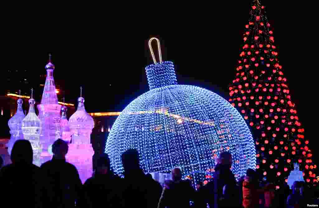 People walk past installations at the Ice Moscow festival in Moscow, Russia, Dec. 29, 2018.