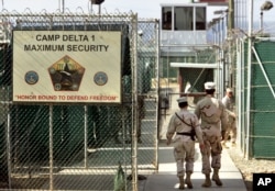 FILE - U.S. military guards walk within Camp Delta military-run prison, at the Guantanamo Bay U.S. Naval Base, Cuba.