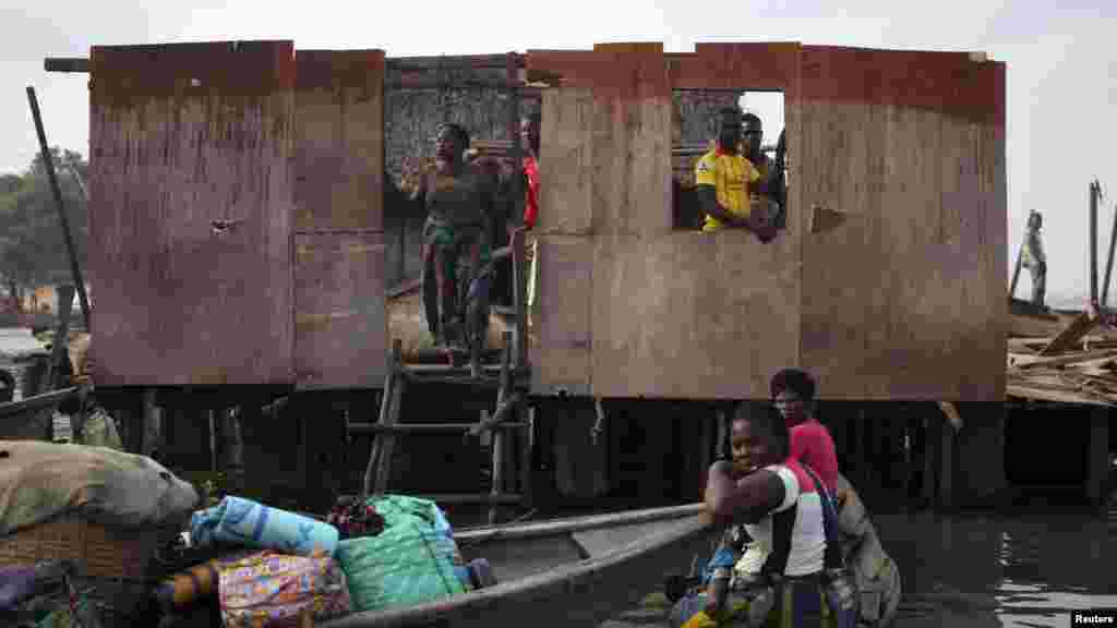 People stand inside a roofless stilt house as the government begins the demolition of illegal homes in Legas.