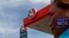 A woman with a sticker on her face reading, "We need $160 per month" protests at a Caltex petrol station in Phnom Penh May 14, 2014. 