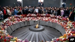 FILE -People lay flowers at a memorial to Armenians killed by the Ottoman Turks, as they mark the centenary of the mass killings, in Yerevan, Armenia, April 24, 2015.