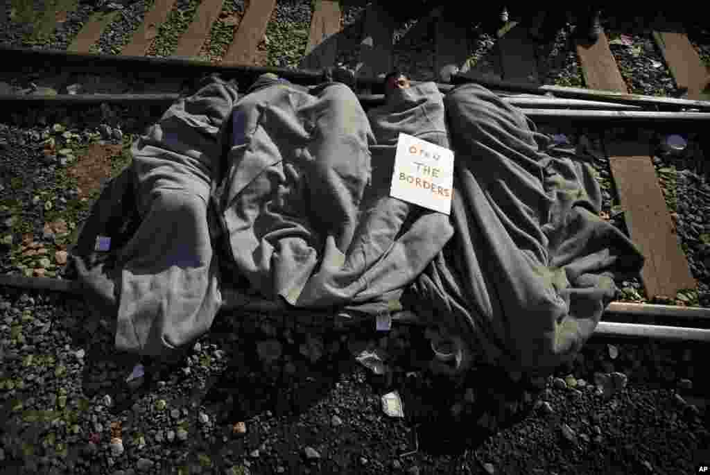 A banner is placed on Syrian migrants who slept on the railway tracks protesting the border closure and preventing freight trains from passing between Greece and Macedonia at the northern Greek border point of Idomeni, Greece.