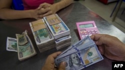 ရန်ကုန်မြို့ ငွေလဲကောင်တာတခုမှာတွေ့ရတဲ့ အမေရိကန်ဒေါ်လာနှင့် မြန်မာငွေစက္ကူများ
