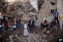 FILE - People gather at the site of a Saudi-led airstrike near Yemen's Defense Ministry complex in Sanaa, Yemen, Nov. 11, 2017.