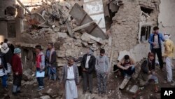 People gather at the site of a Saudi-led airstrike near Yemen's Defense Ministry complex in Sanaa, Yemen, Saturday, Nov. 11, 2017. 