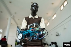 Mohamed Sidy, 14 years old and from Dakar, holds up his team's robot at the 2017 Pan-African Robotics Competition in Dakar, Senegal, May 19, 2017. (R. Shryock/VOA)