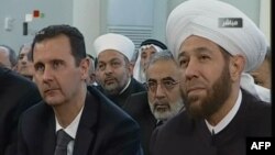 Presiden Suriah Bashar al-Assad (kiri) bersama Mufti Besar Suriah, Ahmed Hassun menghadiri peringatan Maulid Nabi Muhammad di masjid Al-Afram, Damaskus (24/1). 